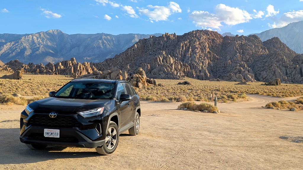 Rental Toyota RAV4 parked in the Alabama Hills with granite boulder formations and the Sierra Nevada in the background