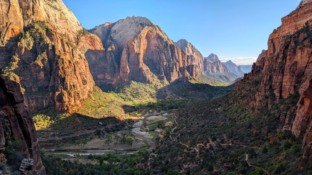 Wide view of Zion Canyon with river, road, and towering cliffs from high above
