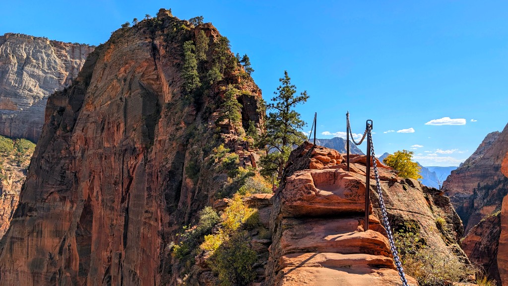 Angels Landing chains on a sandstone ridge above Zion Canyon, blue sky in the background