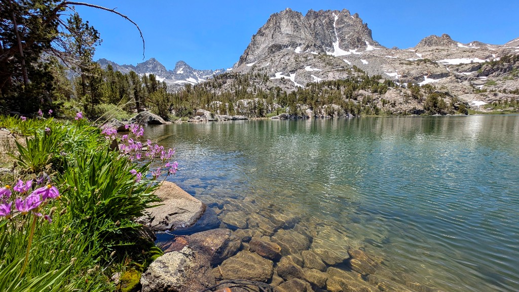 Big Pine Lakes trail in the Eastern Sierra – alpine lake with granite peaks and wildflowers under a clear blue sky