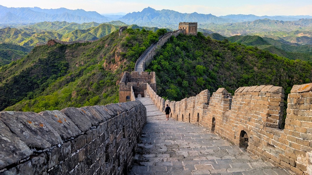 Restored Great Wall section with paved stone steps, intact battlements, and a watchtower on the ridgeline