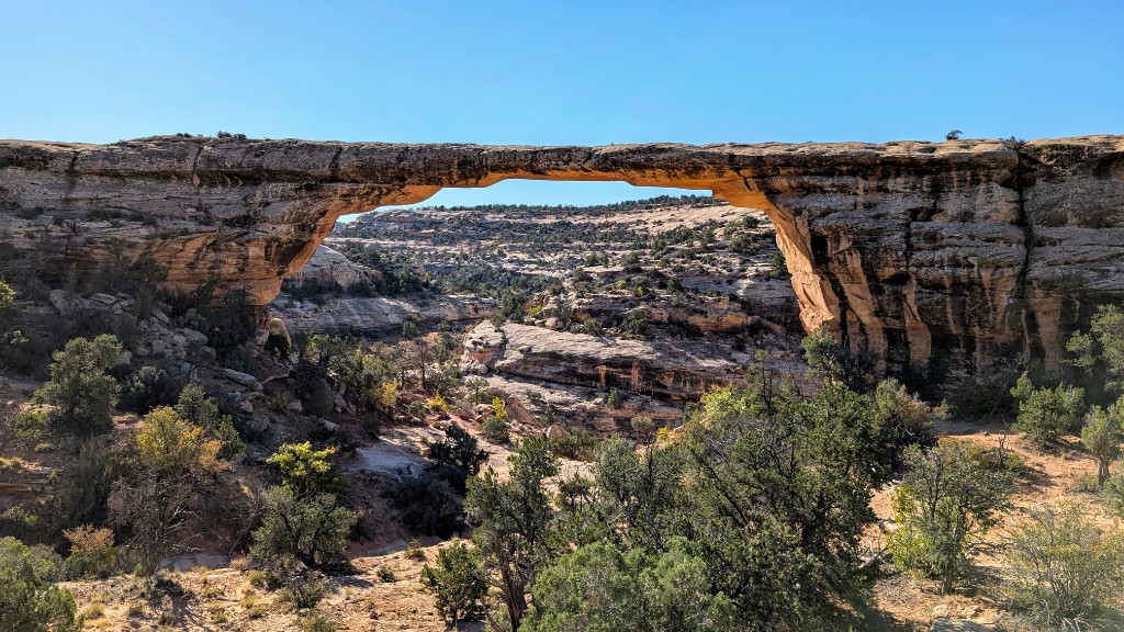 Natural stone bridge spanning a canyon with desert vegetation, Natural Bridges National Monument, Utah