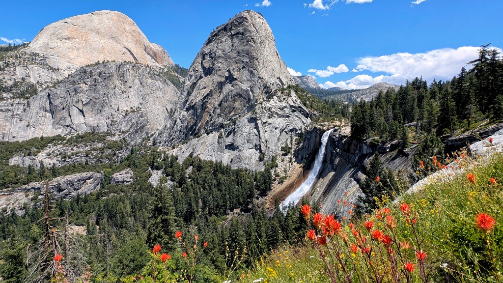 Yosemite Valley granite walls and waterfall on the Mist Trail to Vernal and Nevada Falls, with wildflowers in the foreground